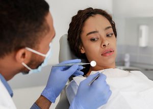 woman looking scared seeing the dental tools near her mouth